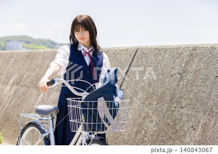 海辺の通学路で自転車を押す女子高校生 海辺の通学路で自転車を押す女子高校生 140843067