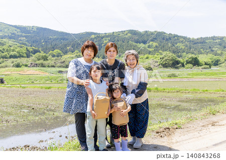 里山の水田で収穫物を手に笑顔を見せる三世代の日本人女性と子供 里山の水田で収穫物を手に笑顔を見せる三世代の日本人女性と子供 140843268