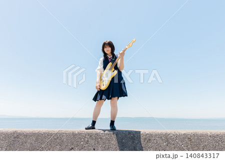 海辺でエレキギターを演奏する女子高校生 海辺でエレキギターを演奏する女子高校生 140843317