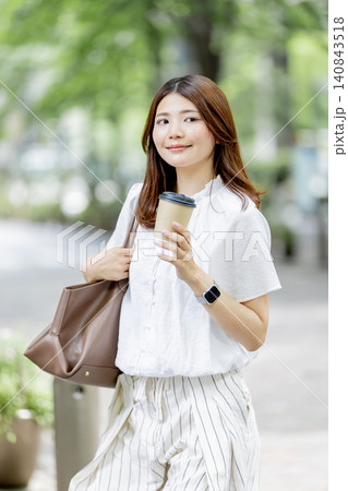 オフィス街でテイクアウトコーヒー持つ日本人女性 オフィス街でテイクアウトコーヒー持つ日本人女性 140843518