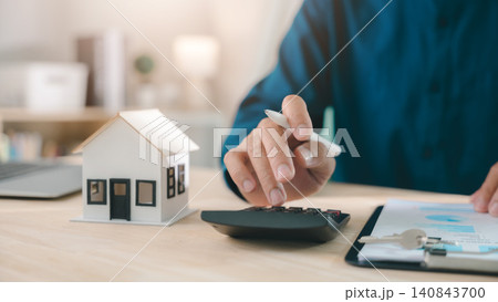 Mortgage loan interest rate payment signing real estate model planning property investment handled by expert using calculator with house keys and documents for home finance purchase deal Mortgage loan interest rate payment signing real estate model planning property investment handled by expert using calculator with house keys and documents for home finance purchase deal 140843700