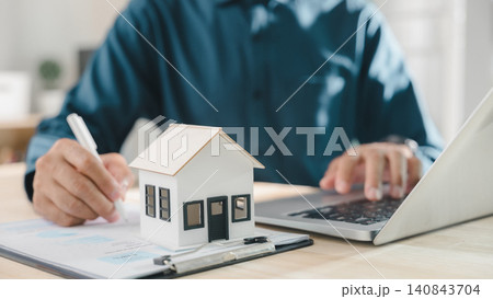 Signing real estate contract property mortgage finance approved home buying document including house investment insurance process for homeowner and tenant using laptop at office work desk 140843704