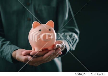 Investor hand holding piggy bank for saving deposit savings invest pension, profit planning shows financial growth and retirement wealth management strategy for future success goals Investor hand holding piggy bank for saving deposit savings invest pension, profit planning shows financial growth and retirement wealth management strategy for future success goals 140843715