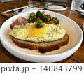 Open-faced scrambled egg and cheese toast served with roasted broccoli and ham 140843799