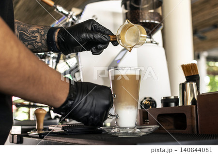 Barista at premium coffee shop preparing a Latte with professional equipment Barista at premium coffee shop preparing a Latte with professional equipment 140844081