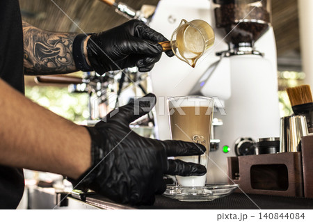 Barista at premium coffee shop preparing a Latte with professional equipment Barista at premium coffee shop preparing a Latte with professional equipment 140844084