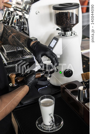 Barista at premium coffee shop preparing a Latte with professional equipment Barista at premium coffee shop preparing a Latte with professional equipment 140844090