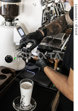 Barista at premium coffee shop preparing a Latte with professional equipment 140844091