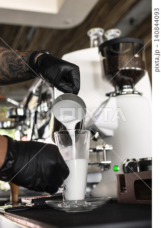Barista at premium coffee shop preparing a Latte with professional equipment Barista at premium coffee shop preparing a Latte with professional equipment 140844093