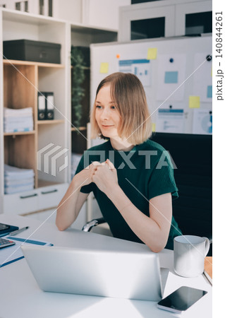 Concept of business working, Businesswoman sitting while writing and checking business analytic document report and holding tablet with computer pc, smartphone on desk in her workstation. Concept of business working, Businesswoman sitting while writing and checking business analytic document report and holding tablet with computer pc, smartphone on desk in her workstation. 140844261