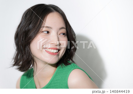 白背景で洋服のビタミンカラーの元気いっぱいの美容やビューティーイメージのかわいい女性 クローズアップ 白背景で洋服のビタミンカラーの元気いっぱいの美容やビューティーイメージのかわいい女性 クローズアップ 140844419