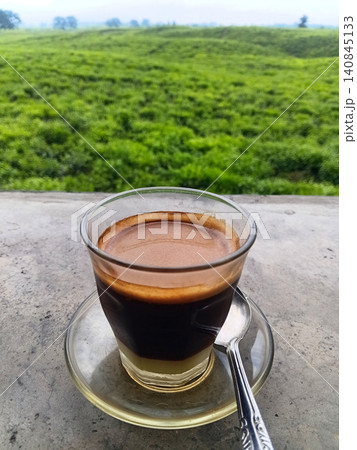 A hot cup of sanger coffee against a green nature background. A hot cup of sanger coffee against a green nature background. 140845133