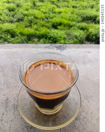 A hot cup of sanger coffee against a green nature background. A hot cup of sanger coffee against a green nature background. 140845135
