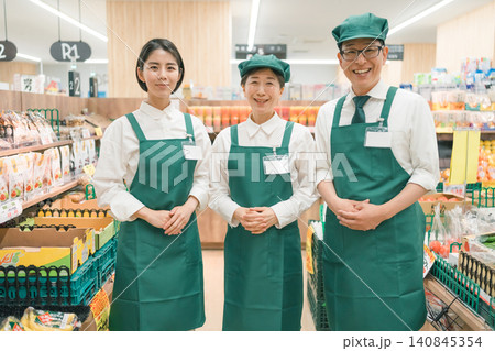 スーパーマーケット売り場に立つ男性店長と2人の女性スタッフ スーパーマーケット売り場に立つ男性店長と2人の女性スタッフ 140845354
