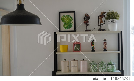 Shelf Decor with Monstera Print and Decorative Items Shelf Decor with Monstera Print and Decorative Items 140845701