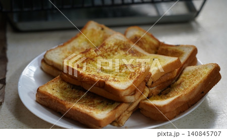 Golden Garlic Bread Stacked on a White Plate Golden Garlic Bread Stacked on a White Plate 140845707