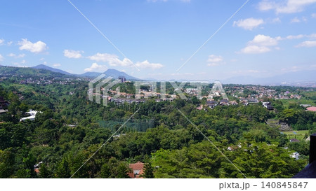 Lush Green Landscape with Buildings and Distant Mountains Lush Green Landscape with Buildings and Distant Mountains 140845847