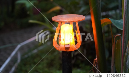 Illuminated Garden Light Among Lush Greenery at Night Illuminated Garden Light Among Lush Greenery at Night 140846282