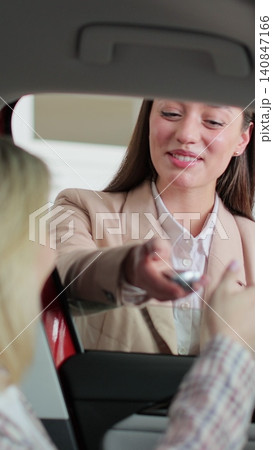 Vertical video Woman agent saleswoman manager give keys to new car happy couple family buyers clients sit inside auto choosing buying automobile dealership. Vertical video Woman agent saleswoman manager give keys to new car happy couple family buyers clients sit inside auto choosing buying automobile dealership. 140847166