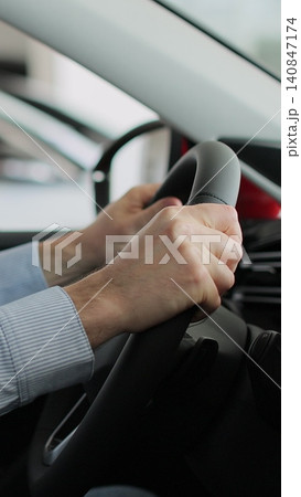 Vertical video Young man auto driver car owner holding steering wheel buy new automobile dealership inside vehicle. Concept of car shopping, buying, and dealership. Vertical video Young man auto driver car owner holding steering wheel buy new automobile dealership inside vehicle. Concept of car shopping, buying, and dealership. 140847174