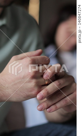 Vertical video Close up a man wiggles his wedding ring on his finger while talking to his wife. Close-up of his hand. Relationship crisis. Vertical video Close up a man wiggles his wedding ring on his finger while talking to his wife. Close-up of his hand. Relationship crisis. 140847274