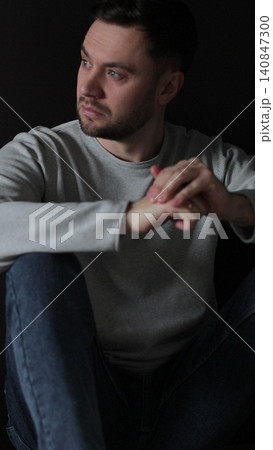 Vertical video Sad man sitting in the dark leaning against the wall in home. Family problems, stress. Vertical video Sad man sitting in the dark leaning against the wall in home. Family problems, stress. 140847300
