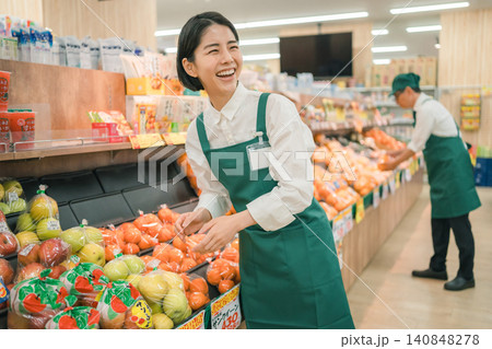 スーパーマーケットの青果売り場で大きく笑う女性店員 スーパーマーケットの青果売り場で大きく笑う女性店員 140848278