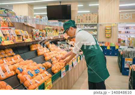 スーパーマーケットのみかん売り場で陳列作業をする男性店員 スーパーマーケットのみかん売り場で陳列作業をする男性店員 140848610