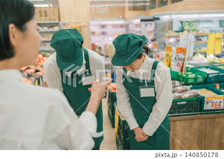 スーパーの売り場で客に叱責される男女の店員二人 スーパーの売り場で客に叱責される男女の店員二人 140850178