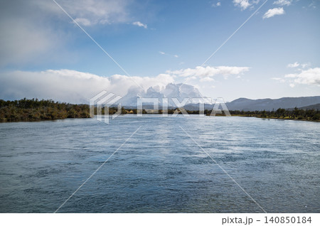 Patagonia mountain river, blue sky, distant peak, cloudy horizon Patagonia mountain river, blue sky, distant peak, cloudy horizon 140850184
