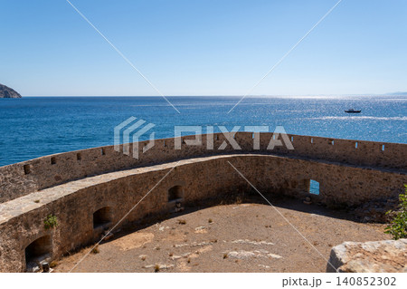 Ancient Venetian fortress walls overlooking blue sea on Spinalonga island Greece Ancient Venetian fortress walls overlooking blue sea on Spinalonga island Greece 140852302