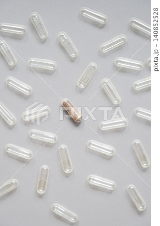 Single filled medicine capsule among empty transparent pill shells. Single filled medicine capsule among empty transparent pill shells. 140852528