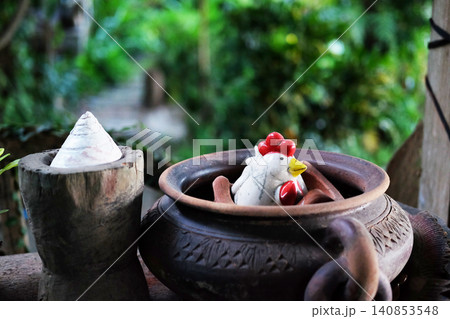Antique decorative items of pottery and ceramic rooster figurines in the tropical garden Antique decorative items of pottery and ceramic rooster figurines in the tropical garden 140853548
