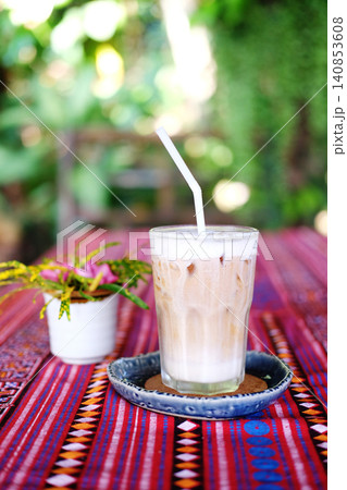 Fresh a clear glass of iced latte coffee with milk foam on table in garden Fresh a clear glass of iced latte coffee with milk foam on table in garden 140853608