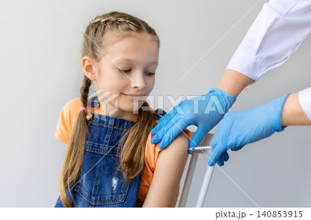 Teen girl receiving vaccination from healthcare worker wearing blue gloves Teen girl receiving vaccination from healthcare worker wearing blue gloves 140853915