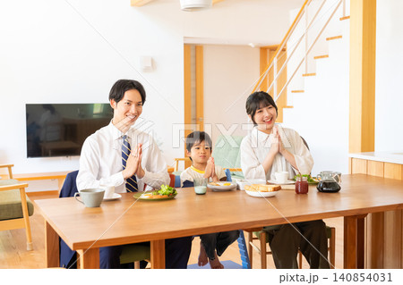 朝食を前に笑顔で手を合わせる3人家族 朝食を前に笑顔で手を合わせる3人家族 140854031
