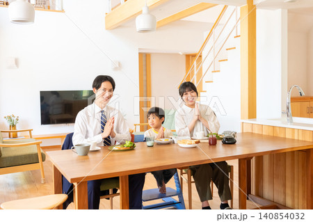 朝食を前に笑顔で手を合わせる3人家族 朝食を前に笑顔で手を合わせる3人家族 140854032