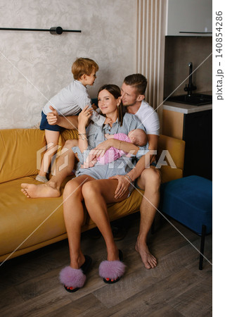 Loving Parents With Children Relaxing At Home Loving Parents With Children Relaxing At Home 140854286