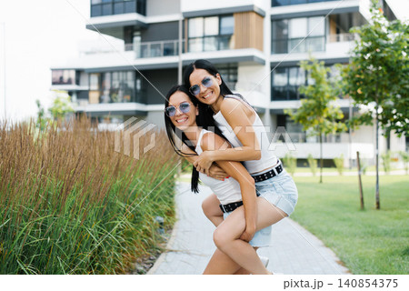 Beautiful Sisters Having Fun and Posing near Architecture Beautiful Sisters Having Fun and Posing near Architecture 140854375