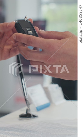 Vertical Video Young man selling car, handshake at car dealership with bought cars in background. Vertical Video Young man selling car, handshake at car dealership with bought cars in background. 140855547