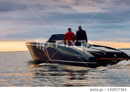 Incredible reflection on the glossy side of a modern motorboat at sunset, the Gulf of Finland, magic reflections on water surface Incredible reflection on the glossy side of a modern motorboat at sunset, the Gulf of Finland, magic reflections on water surface 140857363