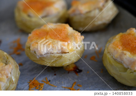 Delight in savory stuffed artichokes fresh from the oven, showcasing golden cheese atop tender vegetables Delight in savory stuffed artichokes fresh from the oven, showcasing golden cheese atop tender vegetables 140858033