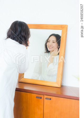 　鏡を見る若い女性 140858207