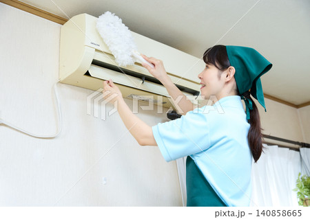 ハンディモップでエアコンを掃除する女性スタッフ ハンディモップでエアコンを掃除する女性スタッフ 140858665