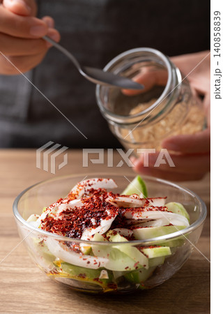 Woman hand preparing roasted sesame seed in a spoon to making cucumber salad 140858839