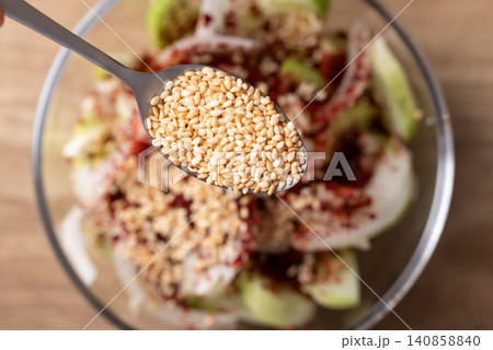 Close-up roasted sesame seed in a spoon  to making cucumber salad, Top view 140858840