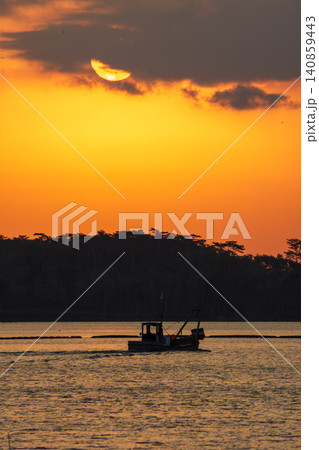 Beautiful golden sunset over the river with a small boat and sun reflection on the water. Beautiful golden sunset over the river with a small boat and sun reflection on the water. 140859443