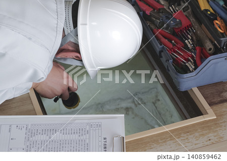 床下点検口から床下を確認 する作業員 床下点検口から床下を確認 する作業員 140859462