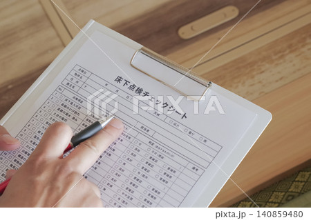 床下点検口から床下を確認 する作業員 床下点検口から床下を確認 する作業員 140859480