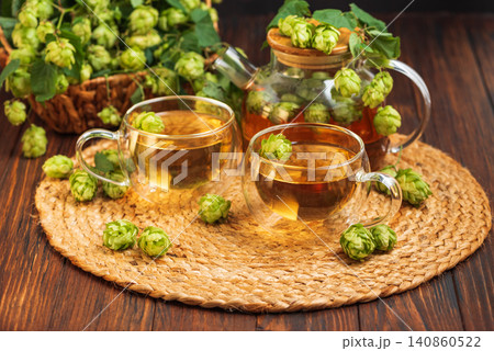 Hops herbal tea with fresh cones brewing on rustic table Hops herbal tea with fresh cones brewing on rustic table 140860522